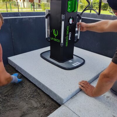 Elevador hidráulico por vacío UPGECO GECO 300 PRO instalado en excavadora para colocar losas hasta 300 kg