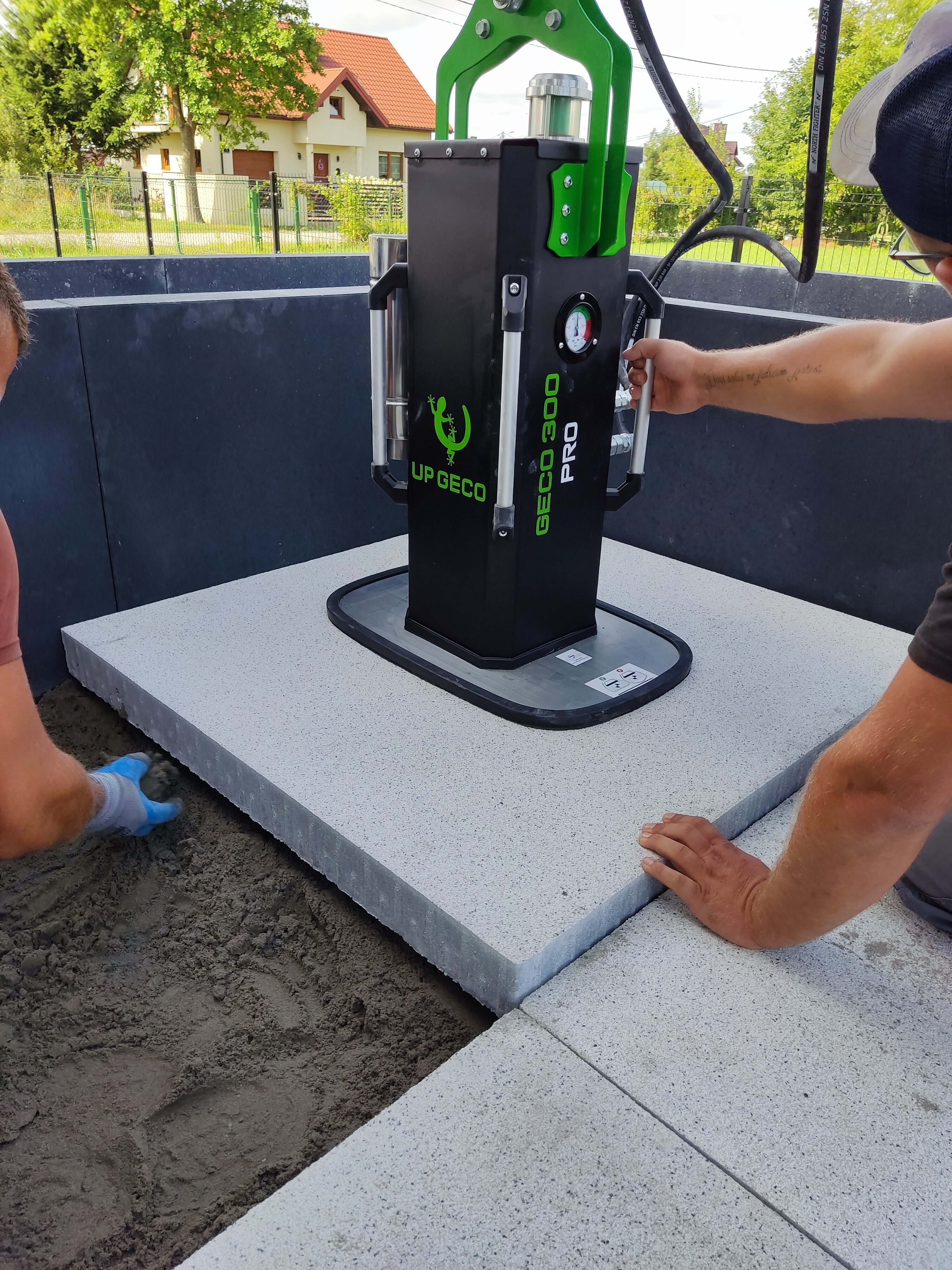 Elevador hidráulico por vacío UPGECO GECO 300 PRO instalado en excavadora para colocar losas hasta 300 kg